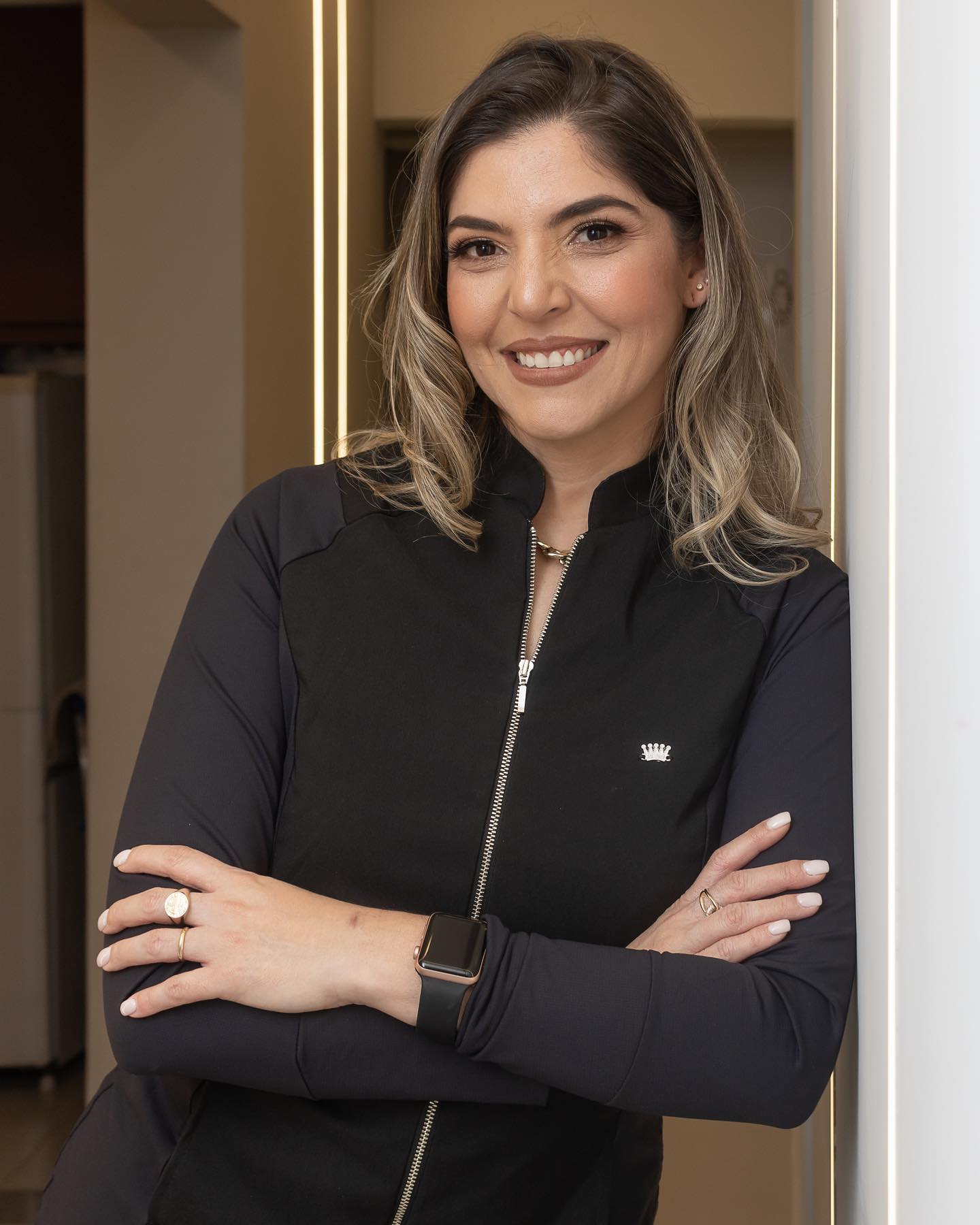 Dra. Ana Paula, dentista em Jundiaí da clínica Oral Mac, sorrindo de braços cruzados em ambiente de atendimento odontológico humanizado.