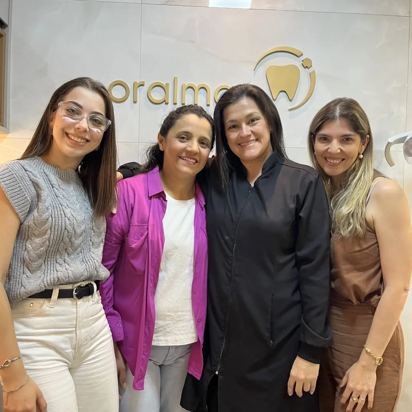 Grupo de dentistas e pacientes na Oral Mac em Jundiaí, destacando o ambiente acolhedor e profissional.